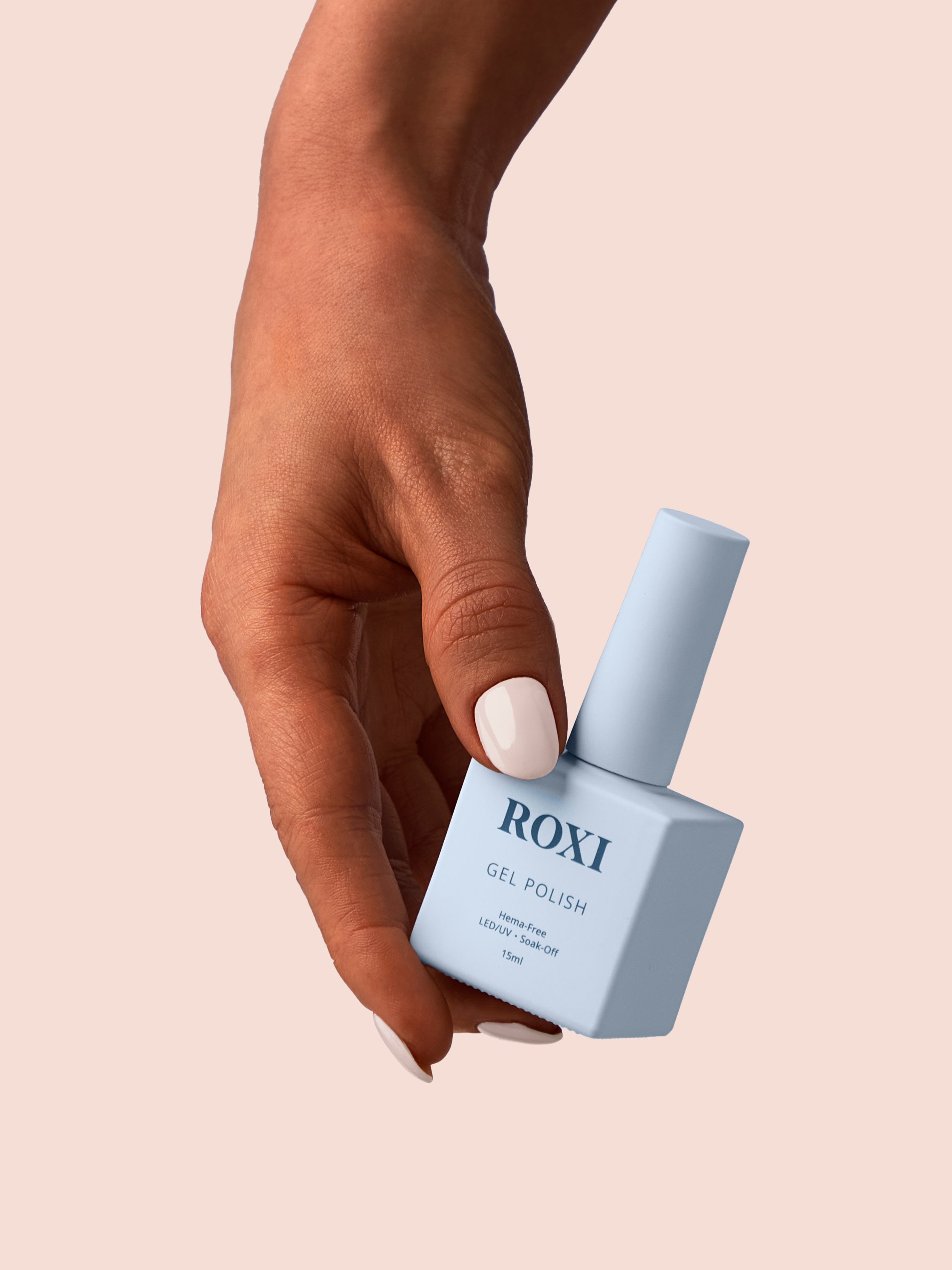 A hand with gel polish nails holding a bottle of Roxi Gel Polish